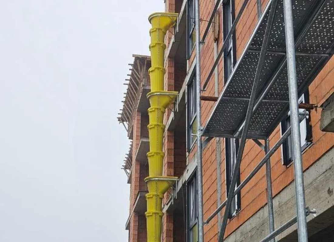 postavljena cev za šut na zgradi na gradilištu